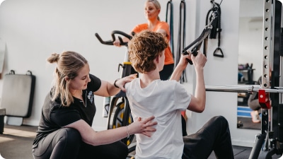 Practitioner helping a young to exercise
