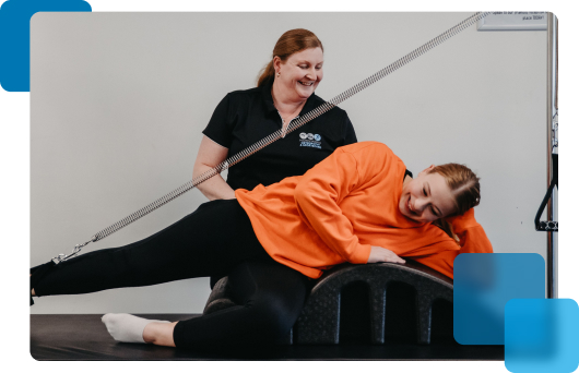 Practitioner helping woman stretching with Pilates